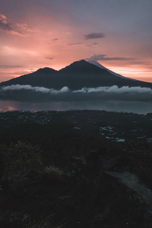 Sunrise view of Mount Batur in Bali with dramatic sky and misty clouds